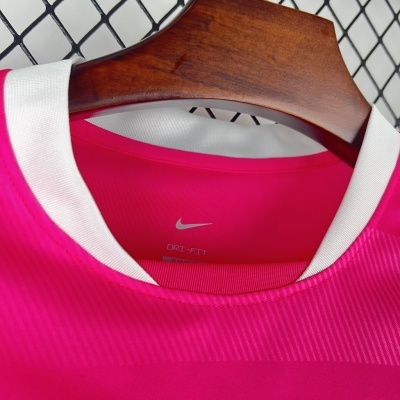 Camisola desportiva cor-de-rosa com gola branca da Nike em cabide de madeira
