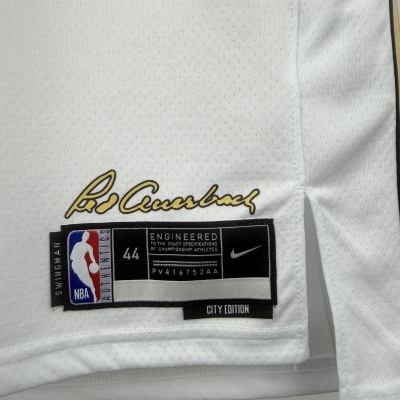 Etiqueta da NBA em peça de roupa branca com assinatura dourada e detalhes em preto e azul