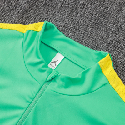 Peça de vestuário verde com detalhes amarelos e etiqueta com símbolo Jumpman