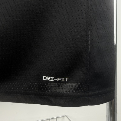 Detalhe de tecido preto perfurado com texto DRI-FIT
