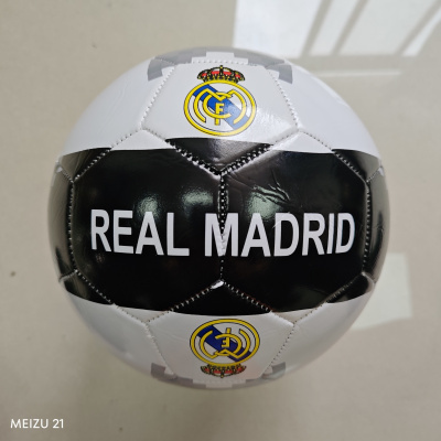 Bola de futebol preta e branca com emblema e texto Real Madrid