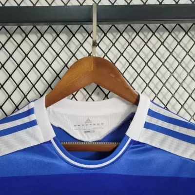 T-shirt desportiva azul da Adidas com riscas brancas nos ombros pendurada em cabide de madeira