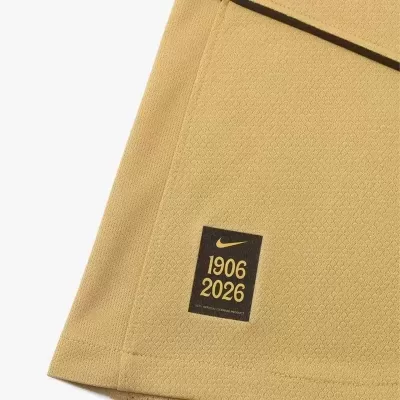 Tecido amarelo com etiqueta Nike preta e texto 1906 2026