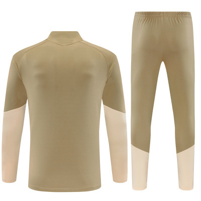 Conjunto desportivo bege e bege claro, camisola de manga comprida e calças justas.