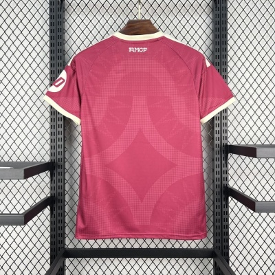 Camisola rosa com padrão geométrico pendurada em suporte metálico