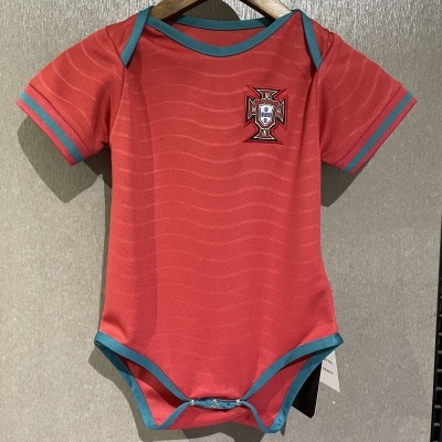 Body cor de tijolo com detalhes azul-acinzentados e emblema da FPF, pendurado num cabide de madeira