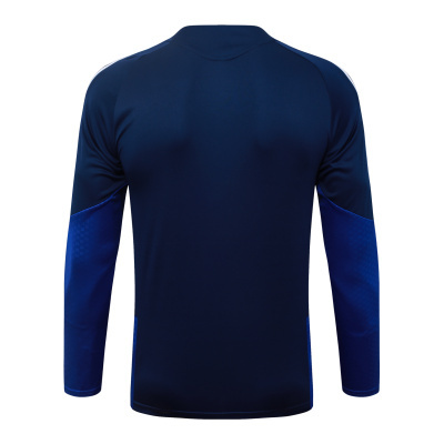 Camisola desportiva azul escuro com detalhes em azul e branco vista por trás