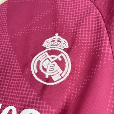 Logótipo bordado do Real Madrid em tecido desportivo rosa com padrão de pontos