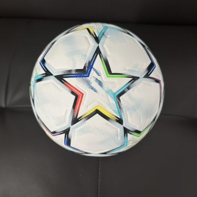 Bola de futebol branca com estrelas coloridas sobre superfície preta