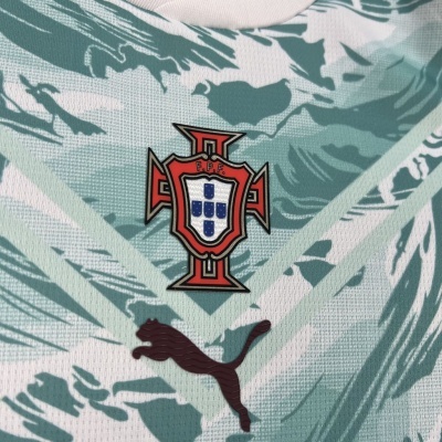 Tecido com padrão abstracto verde e branco, emblema F.P.F. e logótipo Puma preto