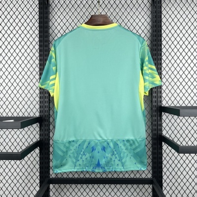 T-shirt desportiva verde-água com detalhes amarelo neon e padrão geométrico azul pendurada num cabide