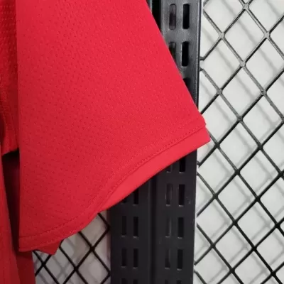 Manga de t-shirt vermelha em malha perfurada pendurada em estrutura metálica