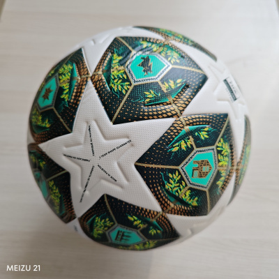 Bola de futebol branca com padrão colorido sobre superfície de madeira clara