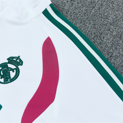 Casaco desportivo branco com riscas verdes e vermelhas e emblema bordado do Real Madrid