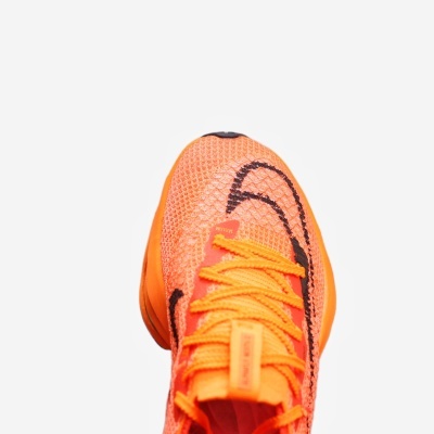 Tênis de corrida laranja com cadarços amarelos e detalhes pretos