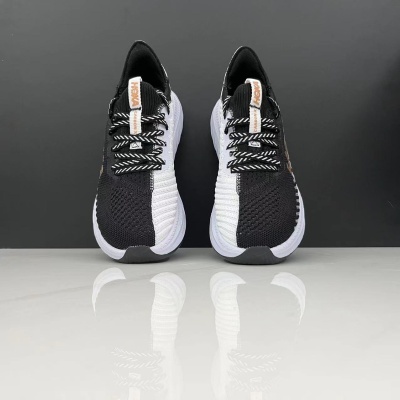 Sapatilhas desportivas bicolores preto e branco com sola branca e etiquetas com texto