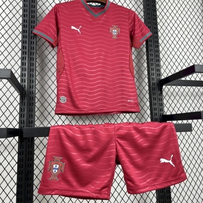 Conjunto desportivo vermelho com camisola e calções e emblemas de Portugal numa estante