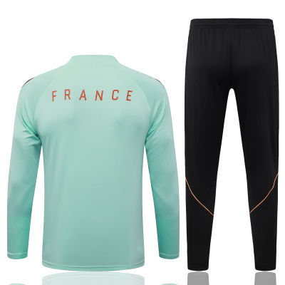 Conjunto desportivo azul clara com calças pretas e texto FRANCE nas costas.