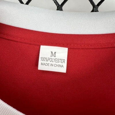 Etiqueta de roupa com tamanho, material e origem, em t-shirt vermelha com gola branca