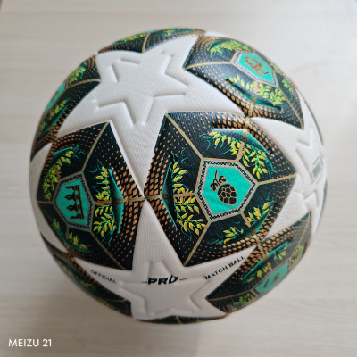 Bola de futebol branca com padrões pretos, verdes e dourados com texturas e relevo