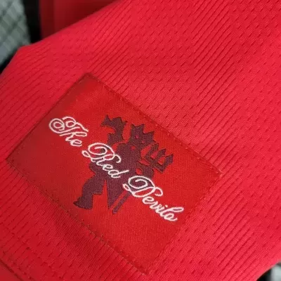 Tecido vermelho com etiqueta The Red Devils e imagem de diabo