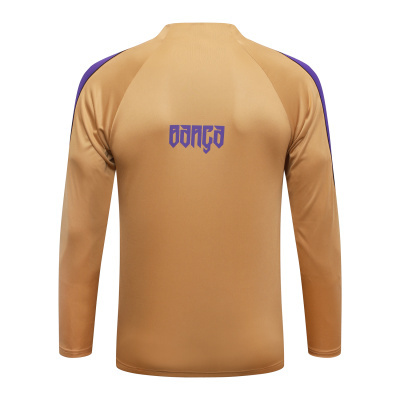 Camisola desportiva bege com logo roxo BARGO nas costas e detalhes roxos nas mangas.