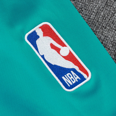 Pano turquesa com logo bordado da NBA em fundo de carpete cinzento