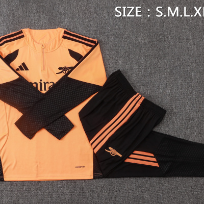Conjunto desportivo laranja e preto com logótipos Adidas e Arsenal sobre fundo cinzento