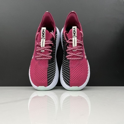 Sapatilhas desportivas rosa e preto da marca HOKA com etiquetas HOKA e ELEVON