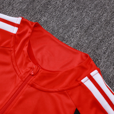 Gola e parte superior de t-shirt desportiva vermelha com listas brancas na manga sobre carpet cinza