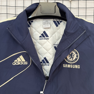 Casaco azul escuro da Adidas com logo do Chelsea e Samsung pendurado num cabide preto