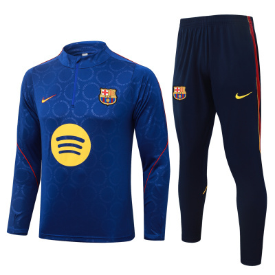 Conjunto azul escuro de camisola e calças desportivas com emblemas do FC Barcelona e logótipos Nike