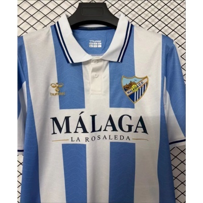 Camisola de futebol azul e branca do Málaga C.F. com gola branca e riscas azuis.
