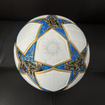 Bola de futebol branca com estrelas azuis e douradas com imagens pretas