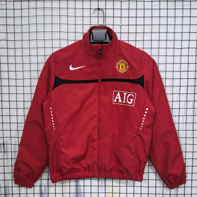 Casaco desportivo vermelho com logos Nike e Manchester United em cabide preto