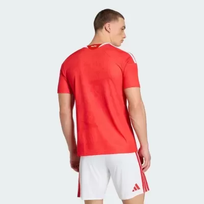 Modelo masculino de costas a usar t-shirt vermelha e calções brancos Adidas