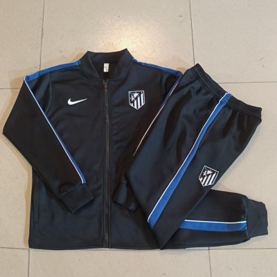 Conjunto de roupa desportiva preta com riscas azuis e brancas com logótipos Atlético Madrid e Nike