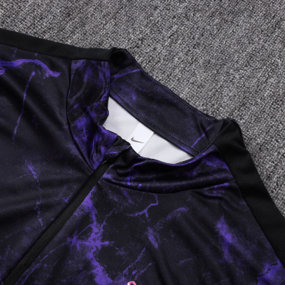 Camisola de desporto preta com padrão roxo, logo Nike e símbolo rosa negro sobre carpete cinza