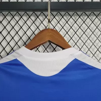 T-shirt desportiva azul e branca pendurada num cabide de madeira
