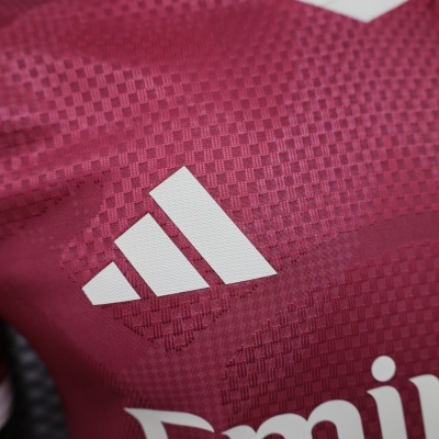 Tecido vermelho quadriculado com logótipo da Adidas e texto branco parcial