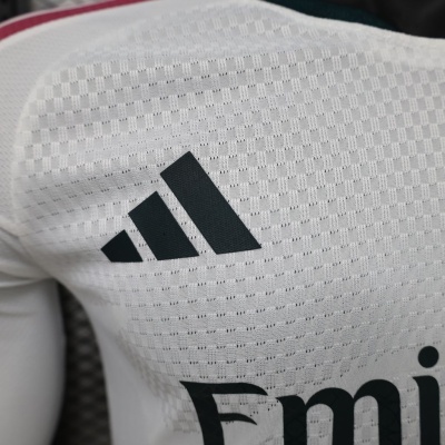 Camisola esportiva branca com logótipo preto da Adidas e texto Emi