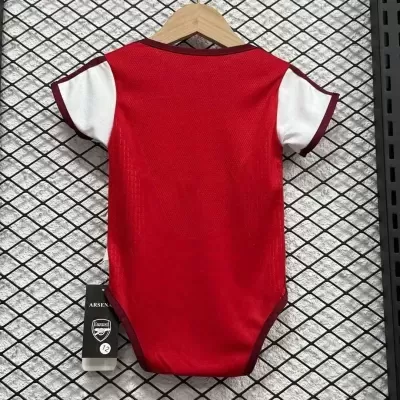 Body vermelho e branco para bebé com etiqueta Arsenal pendurado em cabide