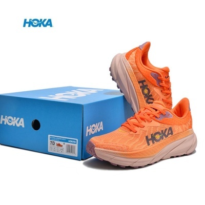 Ténis desportivos laranja HOKA ao lado de caixa azul