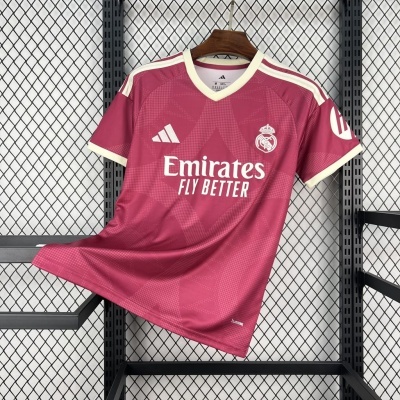 Camisola de futebol cor rosa com logótipos do Real Madrid e Adidas em cabide