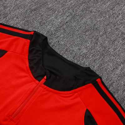 Casaco desportivo vermelho com detalhes pretos e faixa na manga, colarinho alto com fecho.