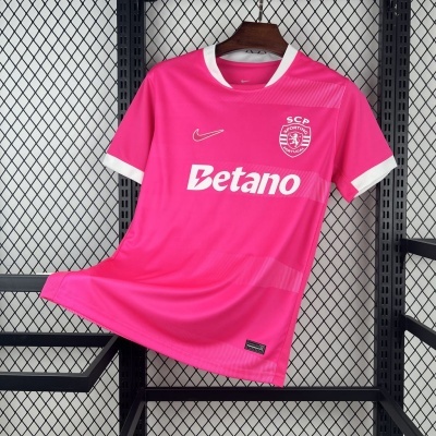 T-shirt de futebol rosa e branca pendurada numa estrutura de metal preta