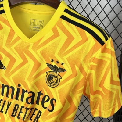 T-shirt desportiva amarela do SL Benfica com padrão laranja e logótipos pretos