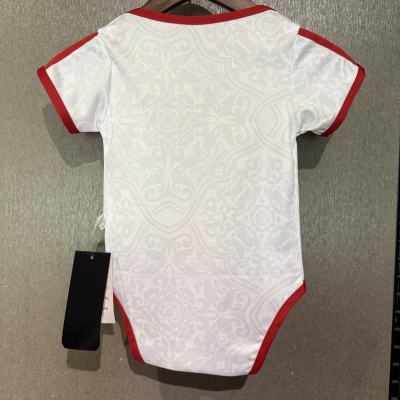 Body de bebé branco com detalhes vermelhos pendurado em cabide