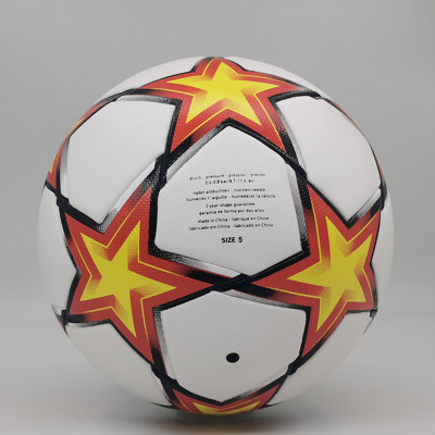 Bola de futebol branca com estrelas amarelas e vermelhas e texto impresso