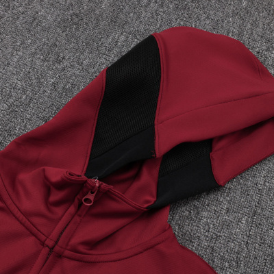 Hoodie vermelho com detalhes pretos no capuz sobre superfície cinzenta